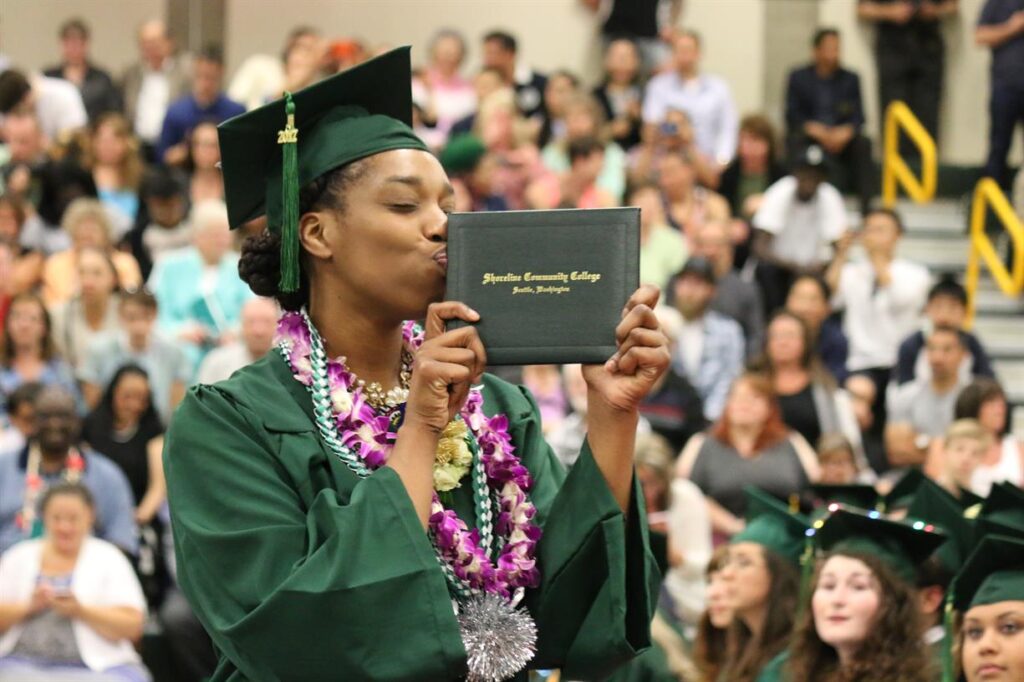 A graduate kisses their diploma.