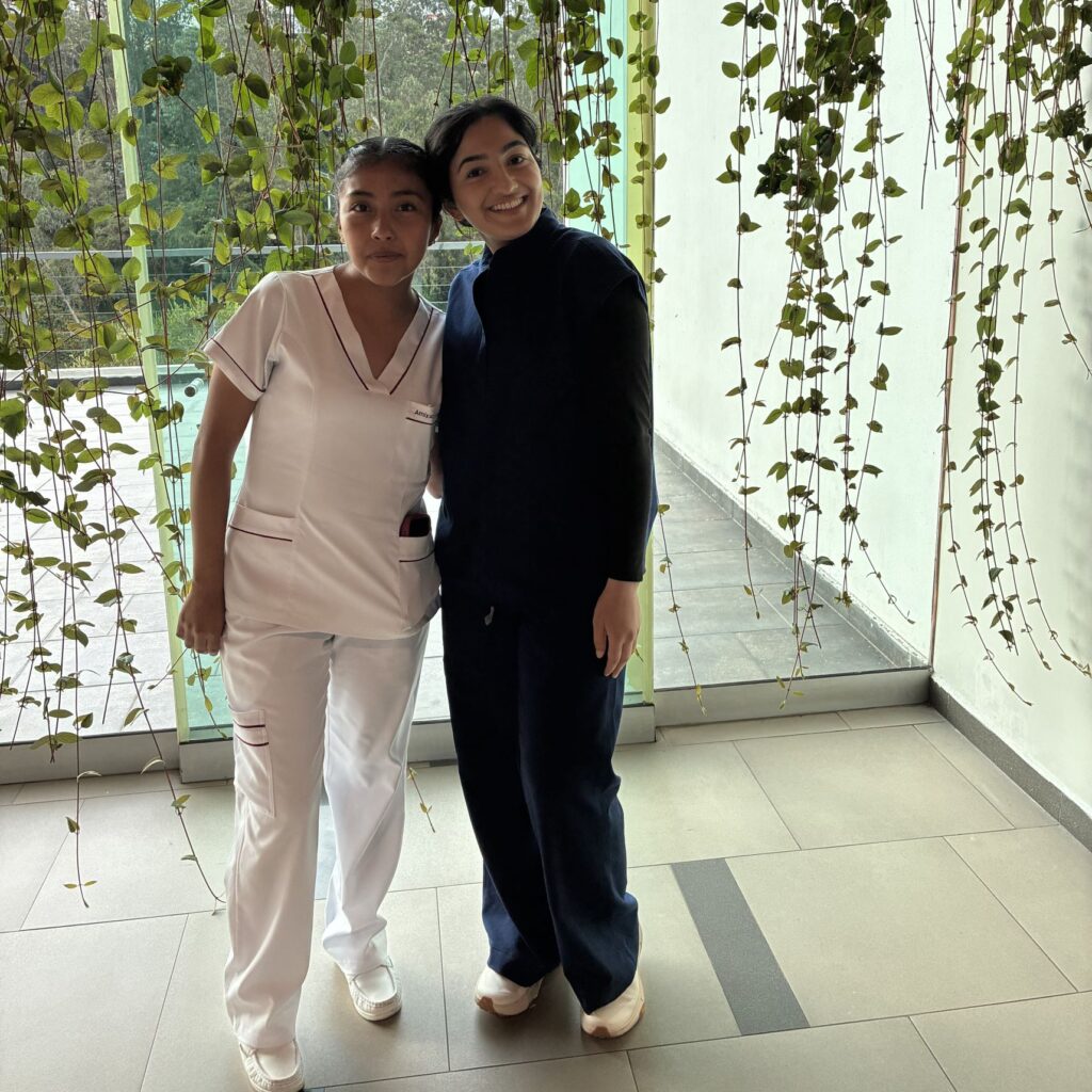 Photo of two nursing students posing by a window. 